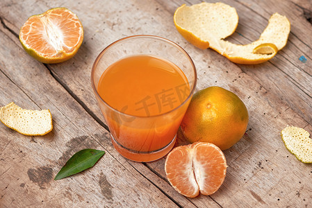玻璃中的柑橘汁和木质背景中的新鲜柑橘