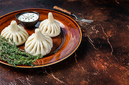 Khinkali 饺子配牛肉和羊肉，放在质朴的盘子上，配上香草。