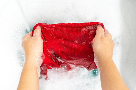湿衣服摄影照片_用洗手液去除红色衣服上的污渍