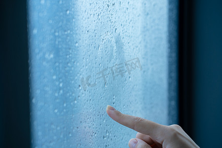 雨中，女手在雾蒙蒙的窗户上画了一个问号。