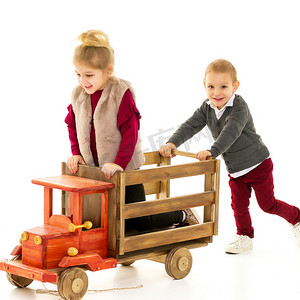 儿童学步车摄影照片_兄妹俩正在玩玩具车。