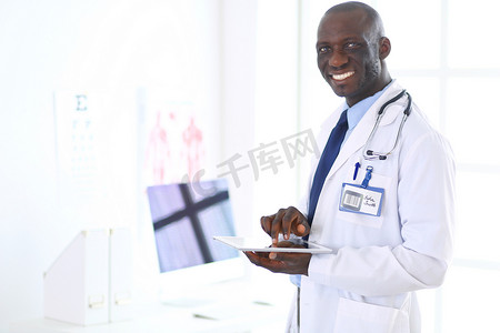 带平板电脑的男性黑人医生站在医院