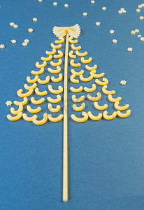 由意大利面制成的圣诞树，纸蓝色背景上的星星。