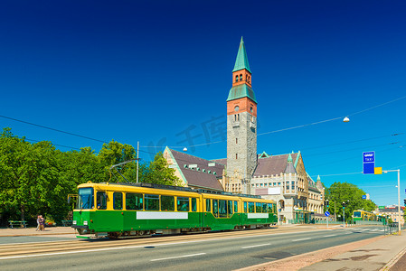 赫尔辛基的城市电车和芬兰国家博物馆古老的历史建筑，背景是清澈的蓝天