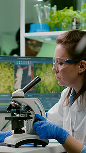 药物科学家在显微镜下观察绿叶样品