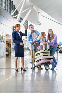 度假的家庭向机场工作人员寻求帮助，背景中有镜头光晕