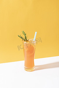 橙色清爽背景摄影照片_冷而清爽的橙色潘趣鸡尾酒，黄色背景上有橙片。