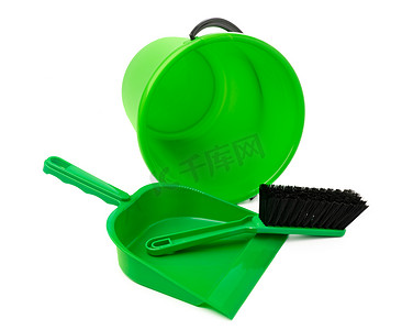 绿色塑料桶和白色背景上孤立的勺子