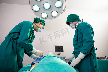 医学医疗医生摄影照片_团队医生和助理在医院手术室、外科医生治疗和手术、呼吸问题、仪器医疗和健康中拿着氧气面罩与病人紧急情况。