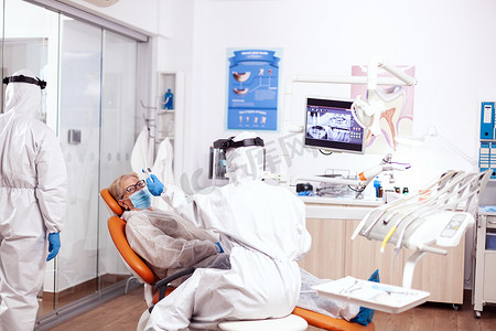 体温计摄影照片_牙医护士穿着防护服给病人量体温