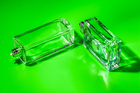 浅绿色背景上的香水玻璃瓶。