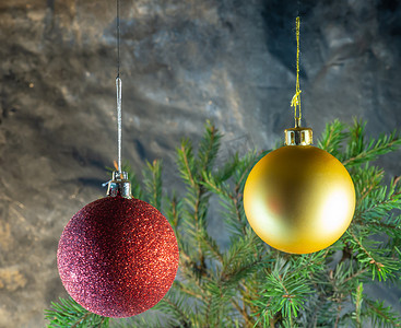 圣诞树木摄影照片_冷杉树枝背景上的红色和金色圣诞球。