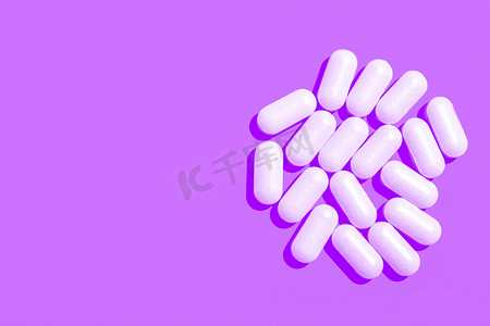 紫色背景上的白色药片胶囊。