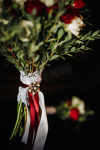 胸花新娘摄影照片_带玫瑰和胸花的婚礼花束。婚礼上的装饰