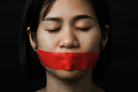 亚洲女人用红色胶带蒙住眼睛包住嘴
