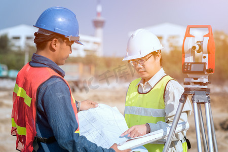 土木工程设计摄影照片_建筑工程师和工头工人在现场检查新基础设施建设项目的施工图