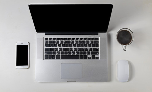 白鼠标摄影照片_顶视图笔记本电脑、鼠标、智能手机、白木桌上的咖啡
