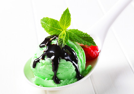 巧克力囊肿摄影照片_绿色冰淇淋加巧克力糖浆