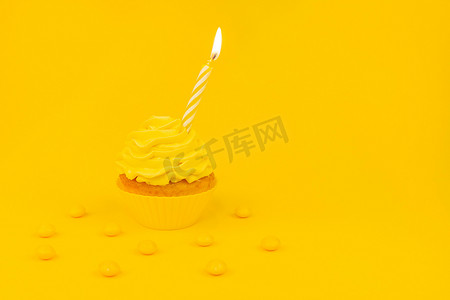 单色生日概念横幅，配有纸杯蛋糕、黄色糖霜和黄色糖果