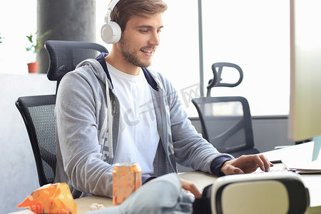 穿着休闲服装的微笑年轻人使用电脑、流媒体播放或演练视频。