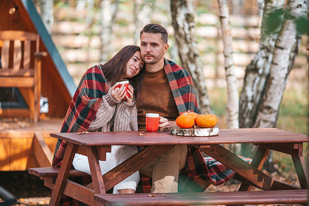 秋天，一对年轻夫妇在他们家的院子里喝咖啡