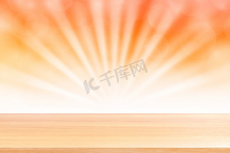 横幅广告摄影照片_空木桌地板在柔和的橙色散景灯光束闪耀渐变背景上，木板空在橙色散景彩色灯光照耀下，彩色散景灯渐变柔和，用于横幅广告
