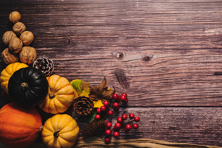 南瓜坚果摄影照片_感恩节快乐，木桌上有南瓜和坚果