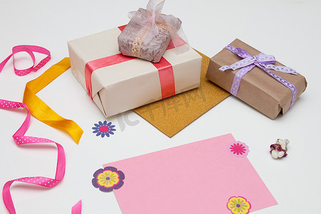 白色背景粉色卡片上有亮色丝带和蝴蝶结的礼盒，装饰用小熊，复制空间，顶视图，生日，感恩节，假期，新年，圣诞节，平躺