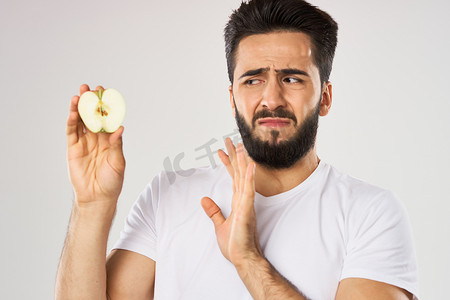 拿着苹果摄影照片_情绪化的大胡子男人手里拿着苹果水果零食