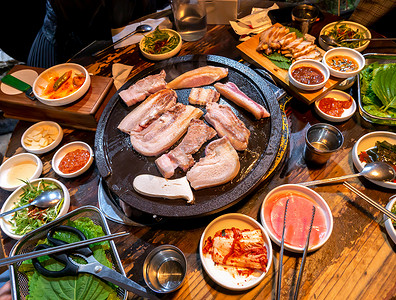 毛肚铁板饭摄影照片_韩国餐厅煎黑猪肉餐，铁板上生菜新鲜美味的韩国美食，特写，复制空间，生活方式