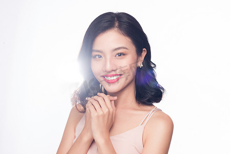 美丽的亚洲女人模型与漂亮的妆容和浪漫的波浪发型的魅力肖像。