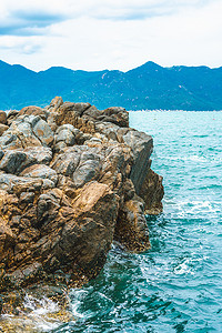 动感水纹水花摄影照片_美丽全景纯蓝色 lazure 空海天际线，生动的棕色灰色岩石破旧的悬崖，水花，积云天空，山岛背景。