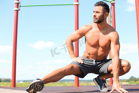 运动型男子在户外锻炼腿部伸展运动