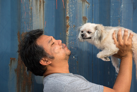 美男摄影照片_亚洲男人和狗快乐地拥抱着容器