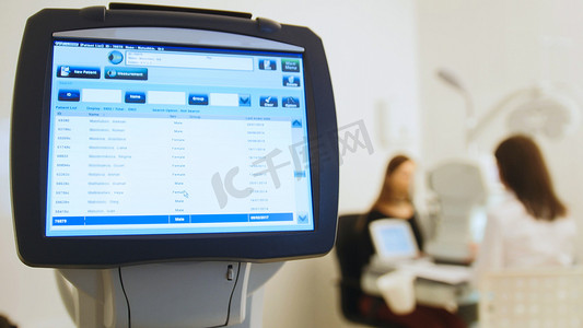 眼科诊所的眼科医生通过现代计算机系统对患者的视力进行诊断-高科技医疗保健