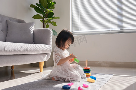 可爱的小女孩在家里的地板上玩积木