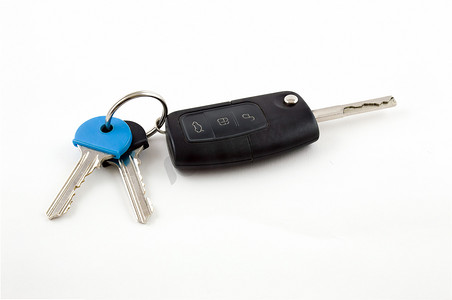 白色汽车背景摄影照片_白色背景上带房门钥匙的汽车钥匙扣