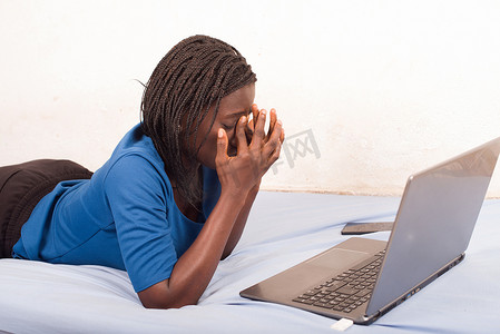 女人躺在床上，厌倦了在互联网上工作
