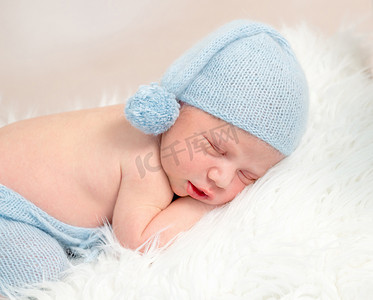 睡在婴儿床上的蓝色服装的新生男孩