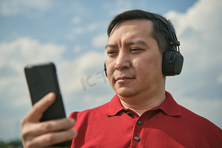中年男子用手机听音乐，特写