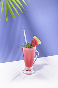 喝西瓜汁摄影照片_新鲜的西瓜汁和西瓜片在颜色背景上。