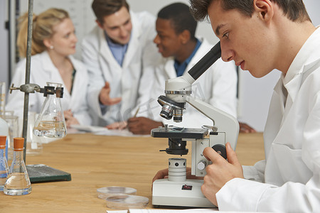 男学生在科学课上使用显微镜