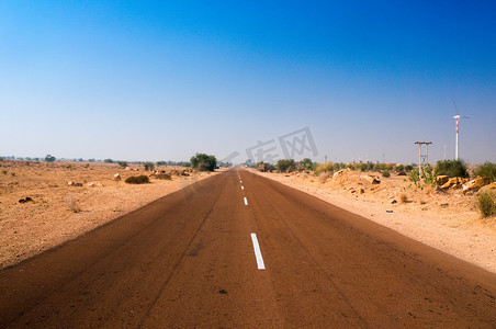 印度拉贾斯坦邦拍摄的狭窄高速公路，两侧都是贫瘠的沙漠