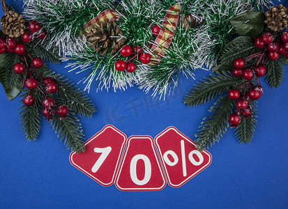大销售额 10%，10% 的圣诞花环在深蓝色背景、顶视图、复制空间、平面布局中。