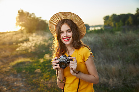 女摄影师手中的相机微笑红唇帽迷人的外观自然