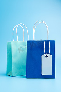 蓝色背景中隔离的两个蓝色购物或礼品袋
