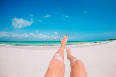 在白色沙滩背景海的女性脚
