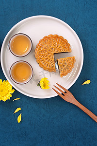 中月饼摄影照片_中秋节蓝色背景月饼的简约布局，创意食品设计理念，顶视图，平躺，复制空间。