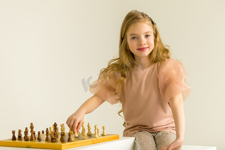 智能造摄影照片_下棋的小女孩。孩子的创造性教育。