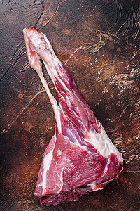 羊腿肉摄影照片_整个生羊腿肉在骨头上。